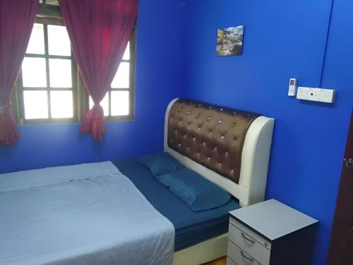 a blue bedroom with a bed and a window at Barokah Seaview Homestay, Bachok in Bachok