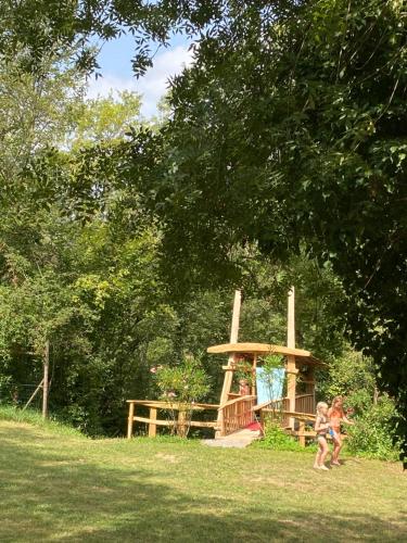 two people walking around a playground in a park at Can Banal - Camping y Masia Rural in Montagut