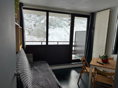 une chambre avec un lit, un bureau et une fenêtre dans l'établissement Studio 4 personnes résidence le Montana au pied des pistes balcon plein sud, à La Mongie
