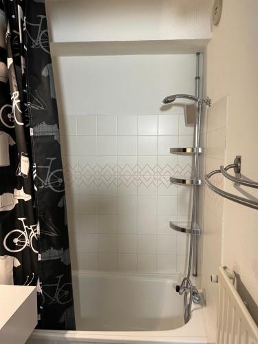 La salle de bains est pourvue d'une douche et d'une baignoire blanche. dans l'établissement Studio 4 personnes résidence le Montana au pied des pistes balcon plein sud, à La Mongie