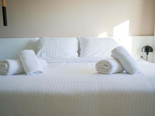 a white bed with towels and pillows on it at Azilo Urban Suites in Kos Town