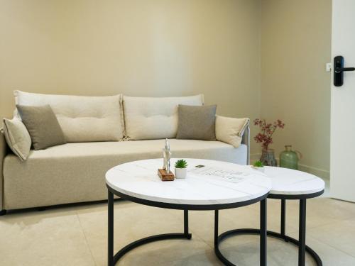 a living room with a couch and two tables at Azilo Urban Suites in Kos Town