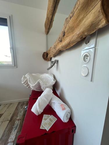 - une boîte rouge avec 2 serviettes dans l'établissement Villa bord de mer, à Plouhinec