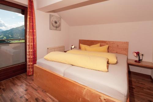a bedroom with a bed and a large window at HOLIDAY Apartments in Jerzens