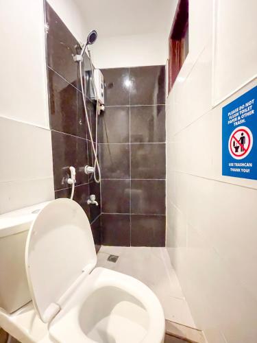 a bathroom with a toilet and a shower at Amos Portside Inn El Nido in El Nido