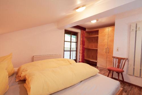 a bedroom with a bed and a chair and a window at HOLIDAY Apartments in Jerzens