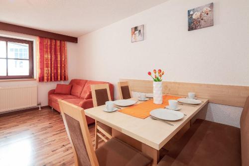 a dining room with a table and a couch at HOLIDAY Apartments in Jerzens