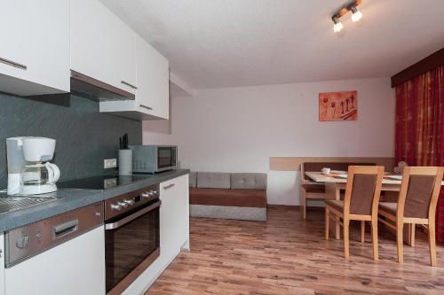 a kitchen and dining room with a table and chairs at HOLIDAY Apartments in Jerzens