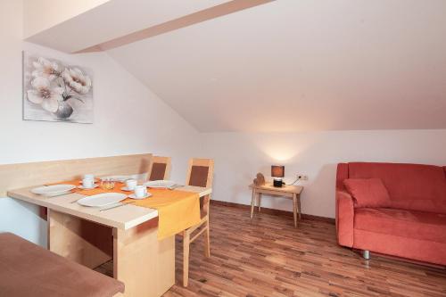 a living room with a table and a red chair at HOLIDAY Apartments in Jerzens