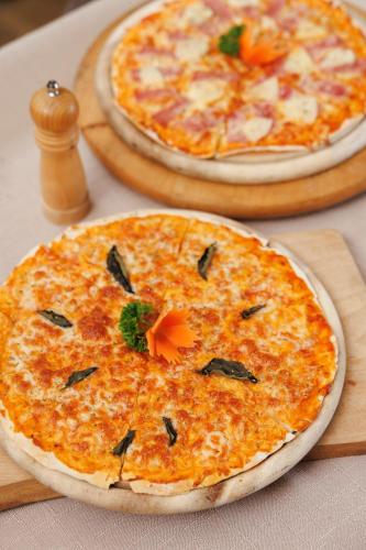 two pizzas sitting on top of a table at Le Charcoa Hotel in Chiang Mai