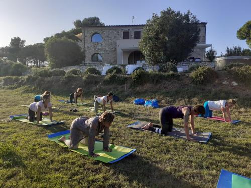 a group of people doing yoga in the grass at Poggio di Sole in Lacona