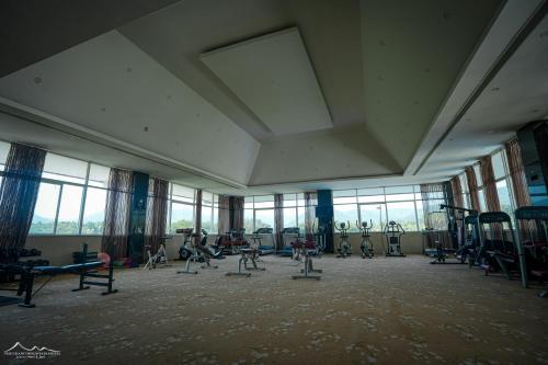 a gym with exercise equipment in a large room with windows at The Grand Mountain Hotel in Matale