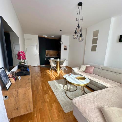 a living room with a couch and a table at Apartment Hera with private garage in Lukavica