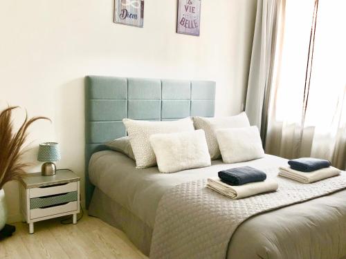 - une chambre avec un lit doté d'une tête de lit et d'oreillers bleus dans l'établissement Maison Cosy La Jolie Fécampoise, à Fécamp