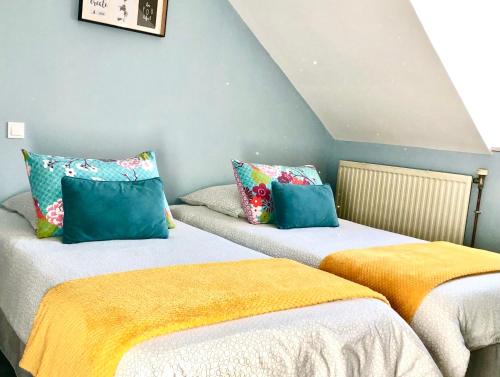 deux lits côte à côte dans une pièce dans l'établissement Maison Cosy La Jolie Fécampoise, à Fécamp