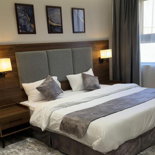 a bedroom with a large bed with two pillows at أساليب بلاتينيوم للشقق المخدومة in Al Madinah