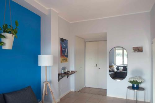a living room with a blue wall and a mirror at Belvedere Quartieri Napoli in Naples