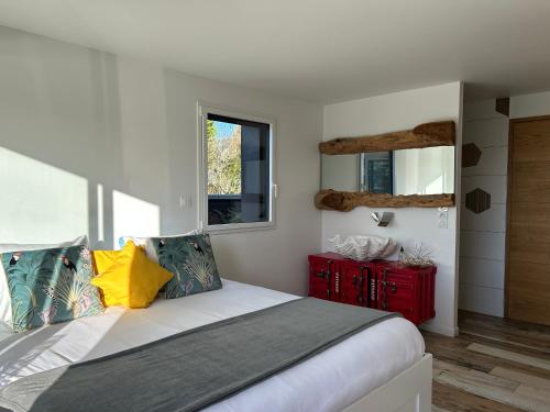 une chambre avec un lit et une armoire rouge dans l'établissement Villa bord de mer, à Plouhinec