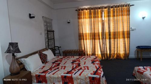 a bedroom with a bed and a window with curtains at Aurora Echo Villa in Matara