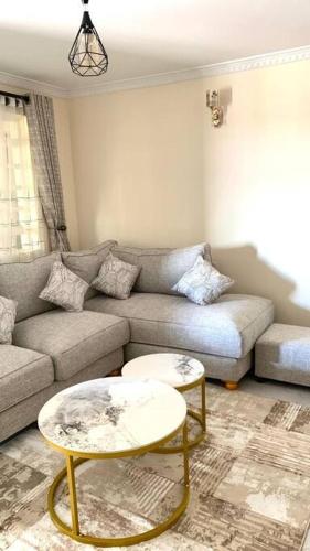 a living room with a couch and two tables at The Royal Residence in Kitengela 
