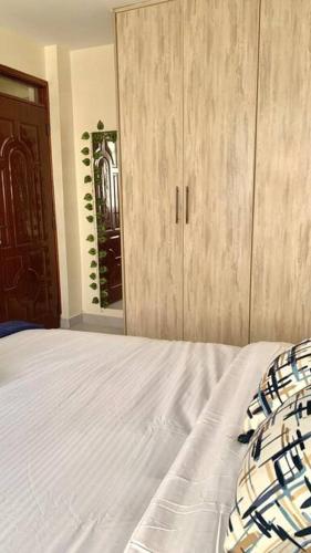 a bedroom with a bed and a wooden cabinet at The Royal Residence in Kitengela 