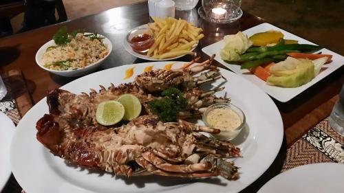 a plate of food with a lobster on a table at Lanka Beach Boutique Bungalows & Grand Villa in Tangalle