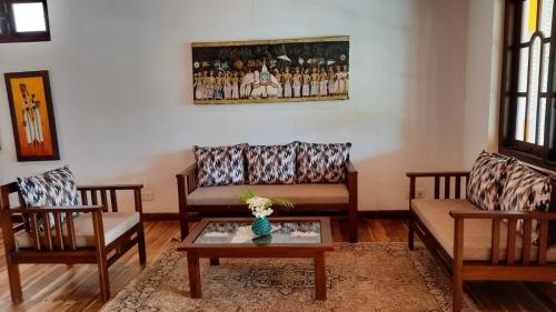 a living room with two couches and a table at Lanka Beach Boutique Bungalows & Grand Villa in Tangalle