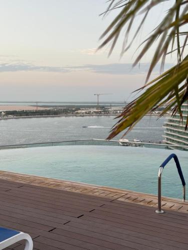 a swimming pool with a view of the water at Coral Holiday Home in Abu Dhabi