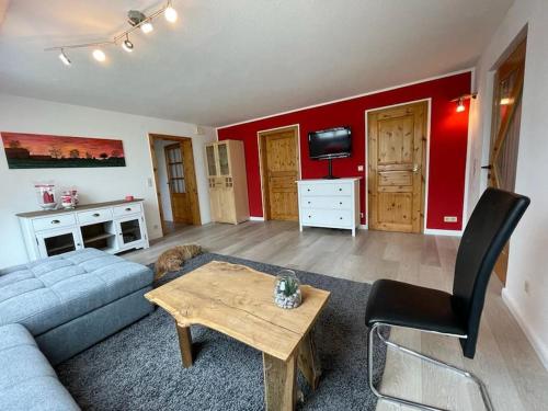a living room with a couch and a table at Schöne Ferienwohnung auf dem Land in Scheeßel