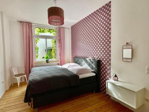 デュースブルクにあるApartment "Am Rheinorange" LOFTSTYLE, 75 Zoll TV, Netflix & Prime, Boxspringbettのベッドと窓のある寝室