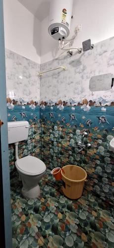 a bathroom with a toilet and a mosaic floor at Mani Kasthuri Illam in Tiruvannāmalai