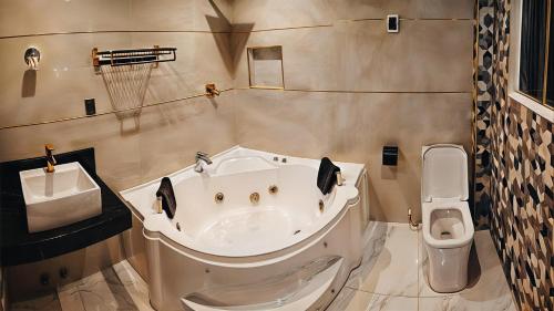a bathroom with a bath tub and a toilet at Hotel yuraq wasi in Torotoro