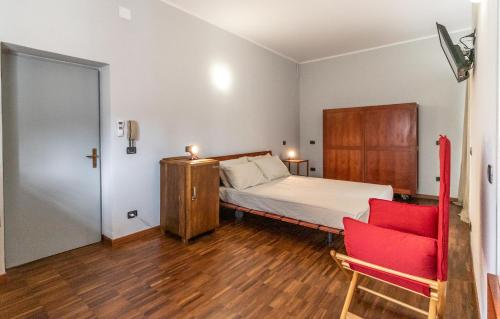 a bedroom with a bed and a red chair at Mina Suites in Cervia