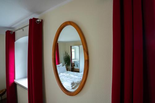 a mirror on a wall with a bed in a room at Littehof - Ferienwohnungen in der Oberlausitz in Löbau