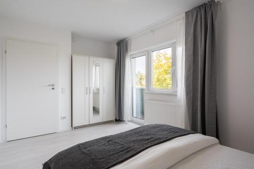 a white bedroom with a bed and a window at Vila Magurele 2 in Măgurele