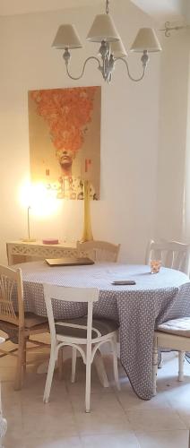 a dining room table with chairs and a painting on the wall at Le Segarius superbe maison médiévale Internet WiFi gratuit Climatisation Jardin in Puisserguier