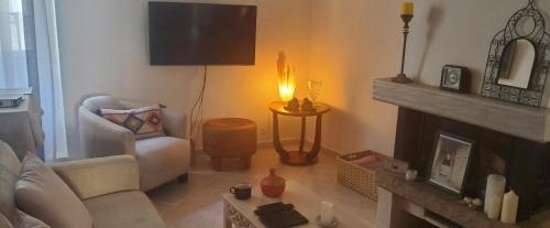 a living room with a couch and a fireplace at Le Segarius superbe maison médiévale Internet WiFi gratuit Climatisation Jardin in Puisserguier