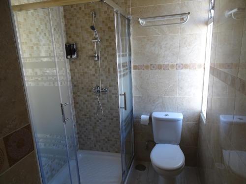 a bathroom with a toilet and a glass shower at Hotel Mexico in Madrid