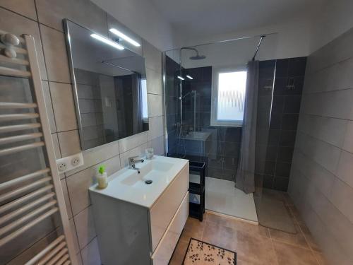 une salle de bain avec un lavabo et une douche dans l'établissement F2 Alata proche d'Ajaccio rez-de-villa, à Alata
