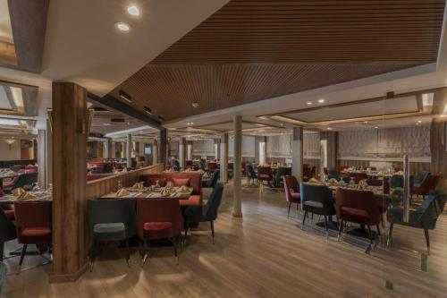 Un restaurante con mesas y sillas y un bar. en Five Stars Nile Cruise from Luxor to Aswan 4 nights included sightseeing, en Asuán