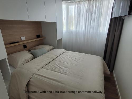 a small bedroom with a bed with a window at Appartement ‘W Vacantia’ in De Haan