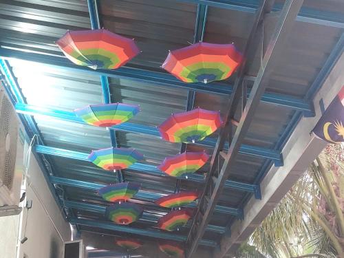 a bunch of colorful umbrellas hanging from a ceiling at Cassa Bonda Std Triple Room in Machang