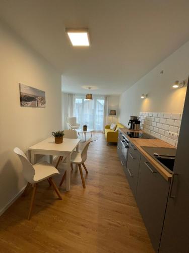 a kitchen and a living room with a table and chairs at Ferienwohnung-Domziegelhof in Schleswig