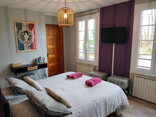 - une chambre dotée d'un grand lit avec des oreillers roses dans l'établissement Chambres D'hôtes le clos de la Bertinière petit déjeuner inclus, à Bosgouet