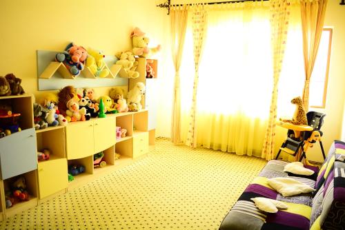 a bedroom with a bed and shelves with stuffed animals at Q Resort and Spa in Săcele