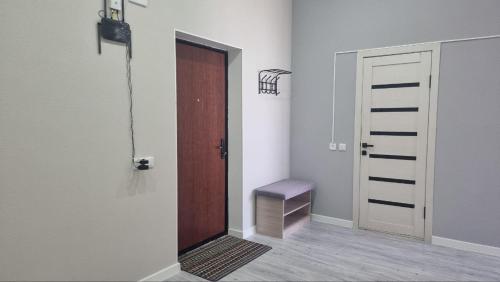 una stanza vuota con una porta e una panca accanto di Квартира на этаже мечты ad Aqtau