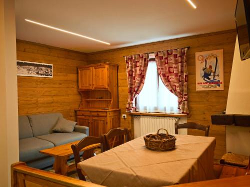 a living room with a table and a couch at Champoluc Apartment in Champoluc