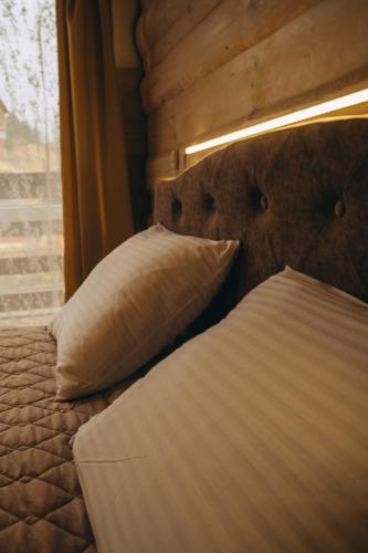 a bed with two pillows and a window at SV HOTEL&camp in Lazeshchyna