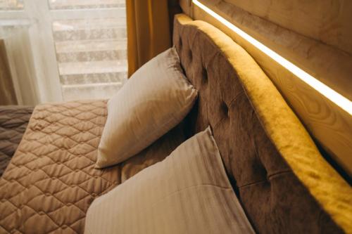 a bed with a yellow headboard and a window at SV HOTEL&camp in Lazeshchyna