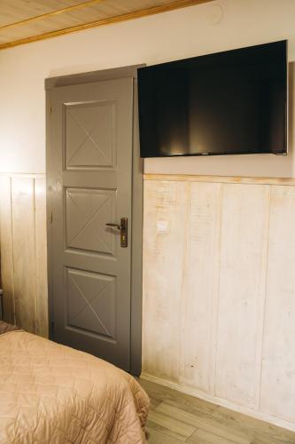 a bedroom with a door and a television on the wall at SV HOTEL&camp in Lazeshchyna